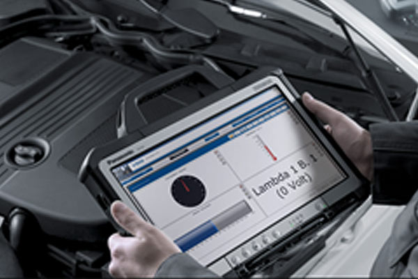 Technician using diagnostic equipment on an engine
