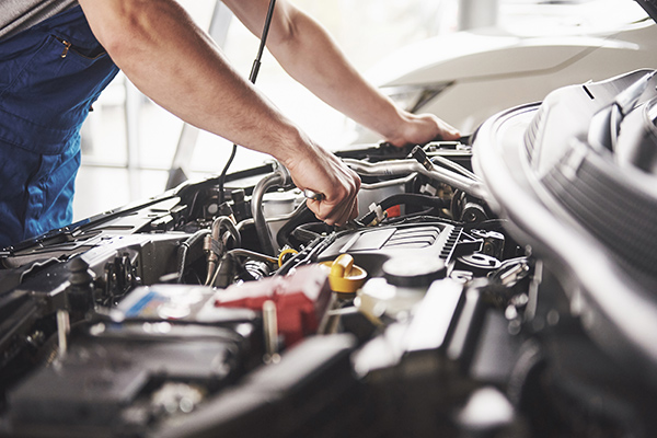 Technician working on a vehicle engine